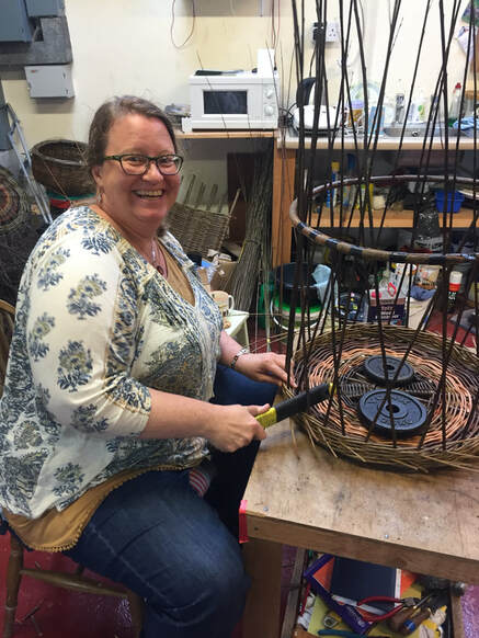 Martha Bird demonstrates use of a rapping iron on her hand crafted basket arts.